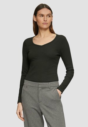 Schwarzes Langarmoberteil mit V-Ausschnitt, aus einem glatten, leichten Stoff, kombiniert mit grauen, taillierten Hosen.