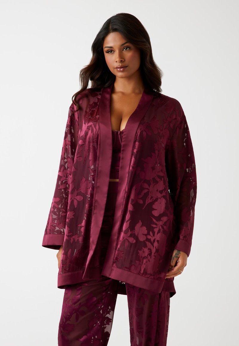 Burgunderroter Satin-Kimono mit floraler Spitzenüberlagerung, langen Ärmeln und Schalkragen, kombiniert mit einem passenden Top und einer Hose.