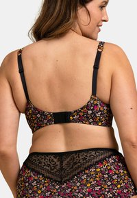 Soutien-gorge noir à motifs floraux avec bretelles réglables, présentant une touche de dentelle à l'arrière. Le tissu est lisse avec des détails floraux colorés.