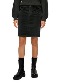 Schwarzer Cordrock mit taillierter Passform, mittellangem Saum, Fronttaschen und Knopfverschluss, kombiniert mit schwarzen Ankle Boots.