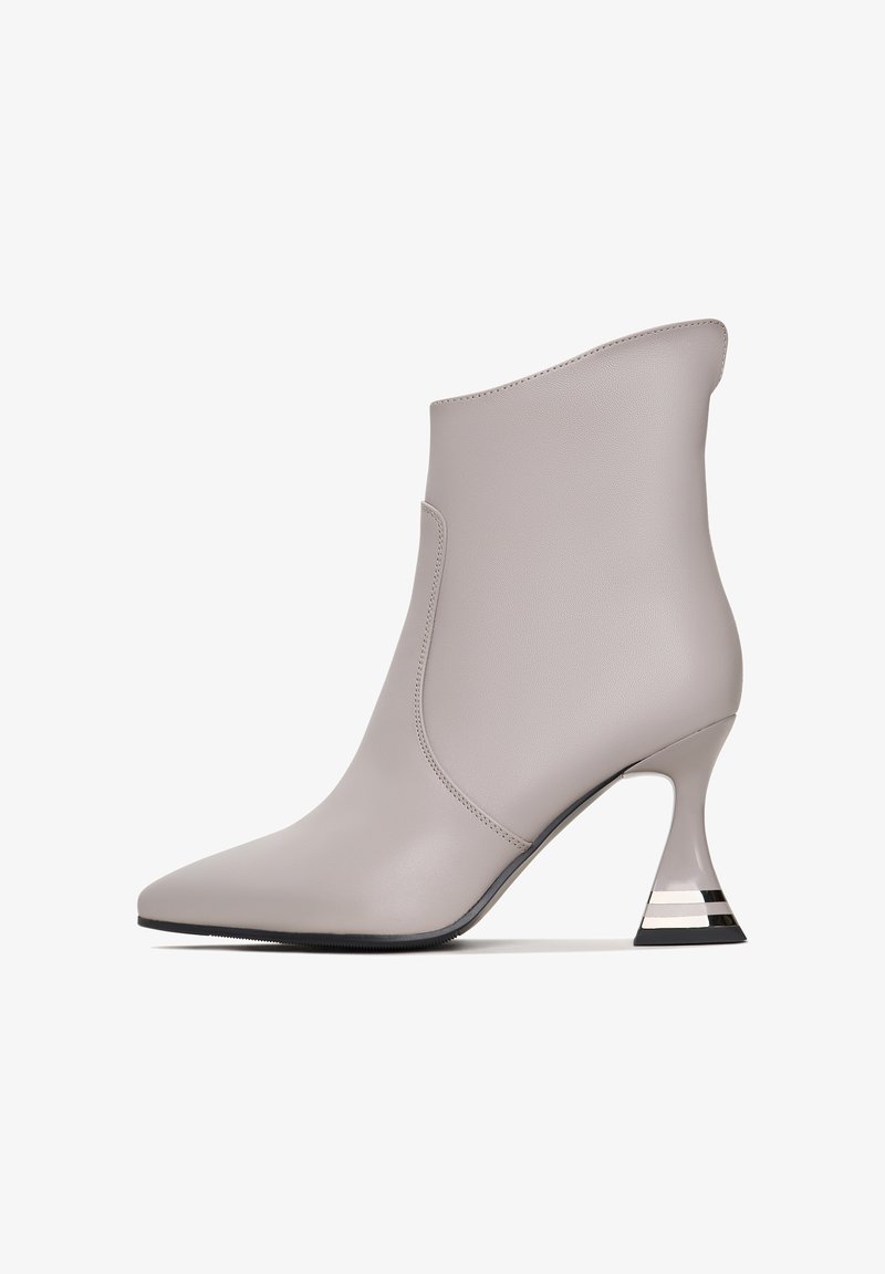 Botină gri din piele la glezna, cu vârf ascuțit și un toc geometric unic, având accente negre și metalice. Textură netedă și design fără cusături.