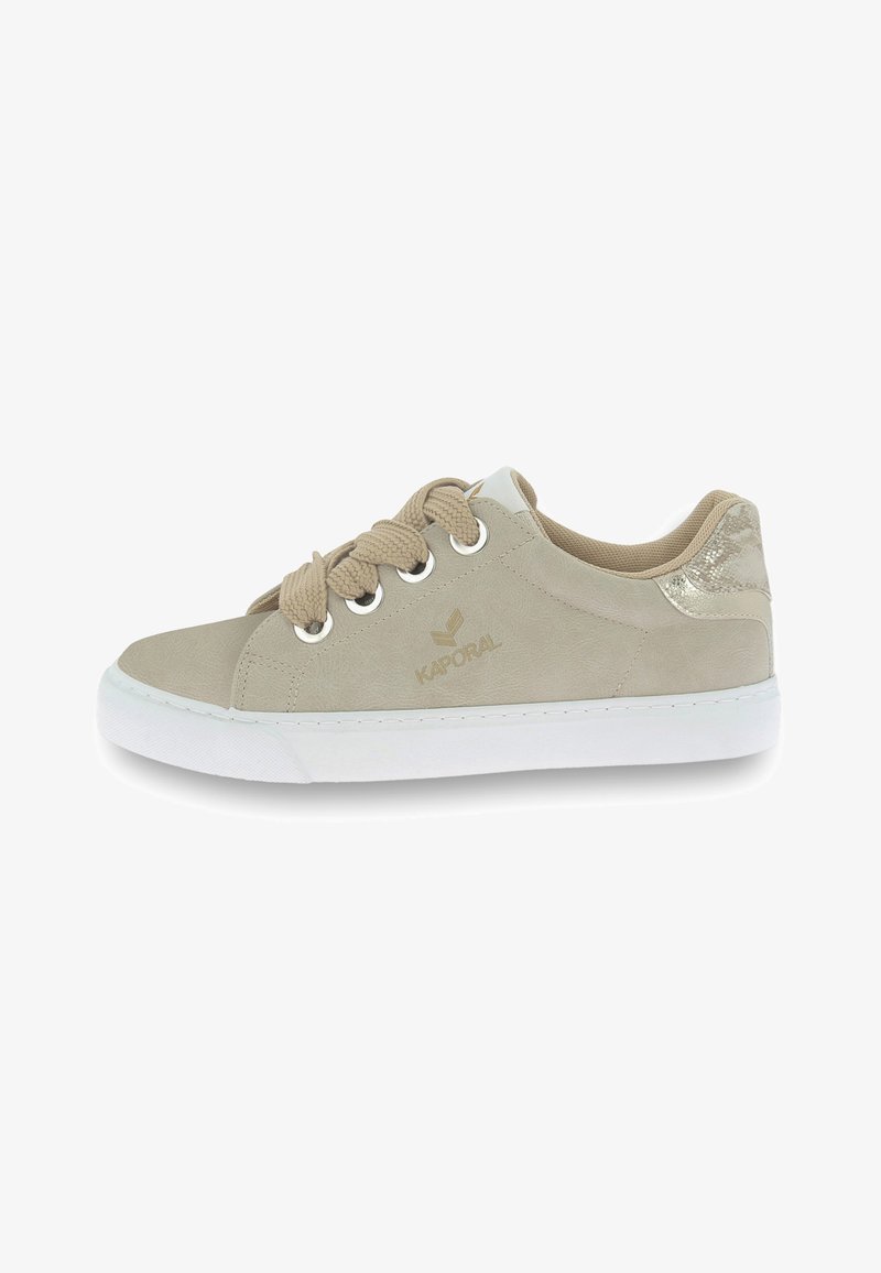 Beige sneaker with suede material, round toe, white rubber sole, and beige laces. Notable metallic accent on the heel and logo detail.
