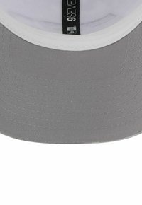 Graue Baseballmütze mit strukturiertem Design, flachem Schirm und weißem Innenfutter. Mit einem Stoffetikett, das im Inneren der Mütze eingenäht ist.