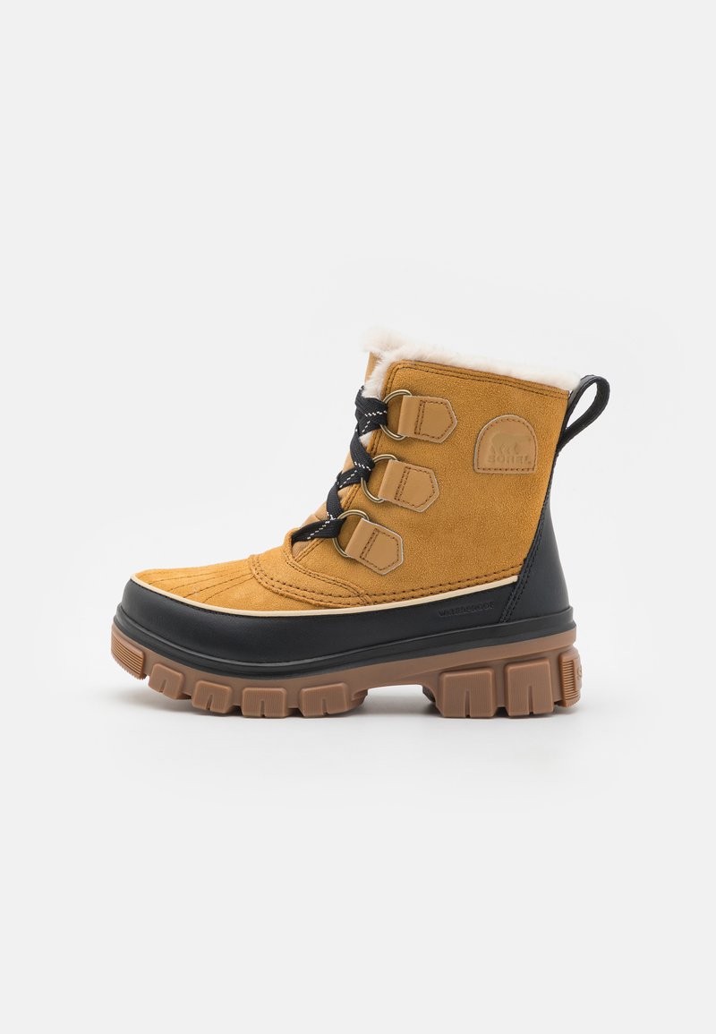 Botte d'hiver en suede marron avec semelle en caoutchouc noir, col en fausse fourrure et trois sangles en tan avec boucles. Dotée d'une semelle extérieure texturée pour une meilleure adhérence.