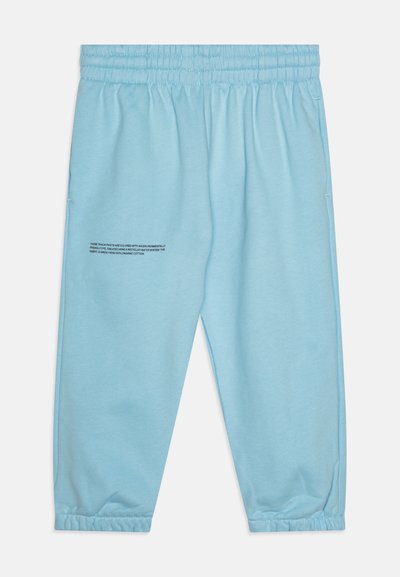 Light blue track pants with elastic waistband, tapered cuffs, and printed text detail. Made from organic cotton. Soft texture.