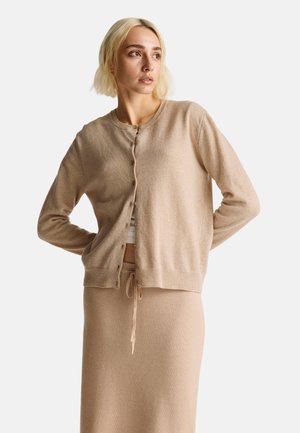 Beige cardigan met lange mouwen en een ronde halslijn, voorzien van knopen aan de voorkant, gemaakt van een zachte, gestructureerde stof.