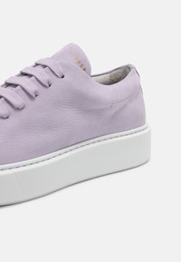 Lila lädersneaker med en strukturerad ovandel, rund tå, vit plattformssula och ton-i-ton snörning. Logotyp i guld på tungan.