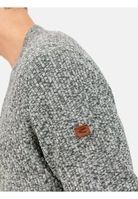 Grauer Strickpullover mit strukturiertem Muster, V-Ausschnitt und einem kleinen braunen Lederetikett auf der Schulter.