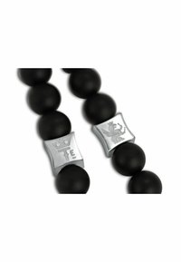 Perline nere opache con accenti rettangolari incisi in argento che presentano una corona e un leone, creando un contrasto di texture e dettagli visivi.