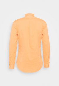 Dlouhý rukáv košile v jasně oranžové barvě, vyrobená z hladkého materiálu, s límečkem na knoflíky, nastavitelným skladem na zádech a zaobleným lemem.