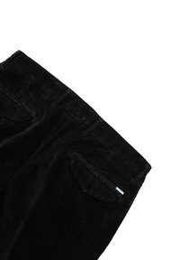 Zwarte corduroy broek met een gestructureerde afwerking, voorzien van twee achterzakken en een klein label op de rechterzak.