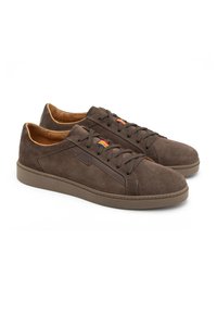Bruine suède sneakers met een gladde textuur, ronde neus en bijpassende rubberen zool. Voorzien van bruine veters en een kleurraccent van het merk aan de zijkant.