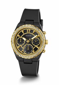 Orologio con cinturino in silicone nero e dettagli in tonalità oro, quadrante nero, embellimenti in cristallo e tre sotto-quadranti. Caratterizzato da indici delle ore audaci e una corona.