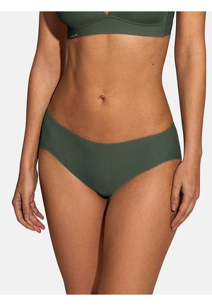 Femme portant un soutien-gorge sans couture et un sous-vêtement hipster assortis couleur vert olive, montrant le ventre et les bras sur fond uni.