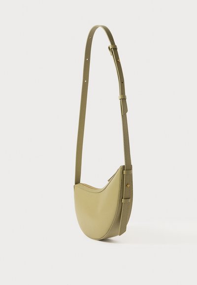 Borsa a spalla in pelle verde a forma di mezzaluna, con tracolla regolabile, hardware dorato e una superficie liscia. Chiusura superiore con zip.