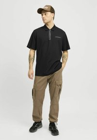 Zwarte poloshirt met een ritskraag en een klein merkdetail, gecombineerd met khaki cargobroek met meerdere zakken en een ontspannen pasvorm.