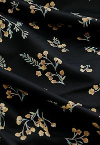 Tela negra con un patrón floral de flores amarillas y hojas verdes, con una textura suave y una apariencia fluida y suave.