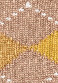 Strickstoff mit einem hellbraunen Hintergrund und gelben Zickzackmustern sowie weißen wellenförmigen Akzenten, der strukturierte Stiche und lebendige Farben zeigt.