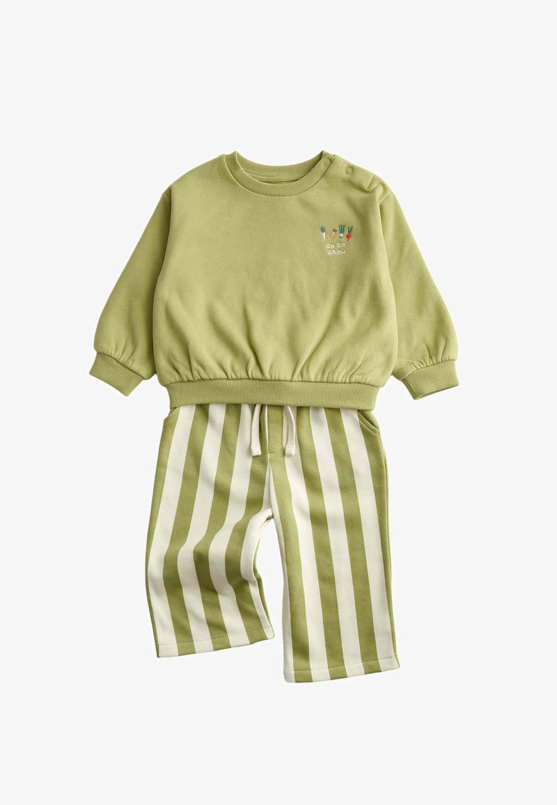 Lichtgroene longsleeve sweatshirt met groente-borduurwerk en tekst "Go Go Grow", gecombineerd met groen-wit gestreepte broek met verticale strepen.