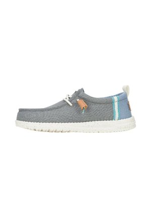Chaussure textile grise avec une semelle en caoutchouc blanche tachetée, des accents contrastants en bleu clair et en sarcelle, et une étiquette en cuir brun près des lacets.