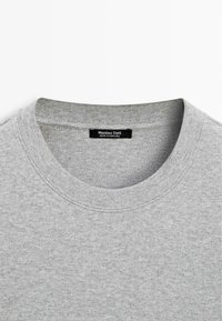 Šedá mikina s vroubkovaným kulatým výstřihem, hladkou texturou a štítkem s nápisem "Massimo Dutti, vyrobeno v Portugalsku."