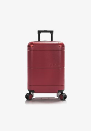 Harde koffer in dieprood met een glanzende afwerking, uitgerust met een telescopische handgreep en vier wielen voor gemakkelijke mobiliteit. Merklocatie weergegeven.