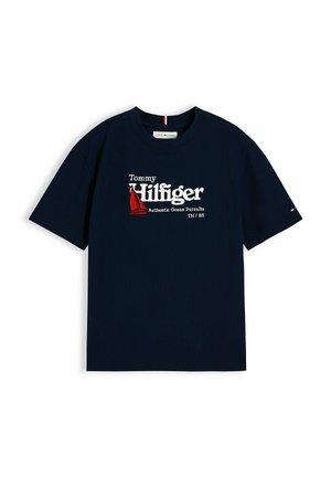 Mørkeblå kortærmet Tommy Hilfiger skjorte med rød sejlbådsgrafik og teksten "Authentic Ocean Pursuits TH / 85" foran.