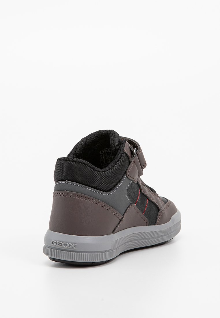 Baskets montantes en cuir gris foncé avec des accents en textile noir, des coutures rouges et une sangle en Velcro. Dotées d'une semelle en caoutchouc gris texturé.