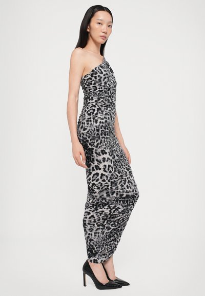 Rochie cu imprimeu leopard, cu design pe un umăr, textură plisată și siluetă ajustată; asortată cu pantofi cu toc înalt negri.