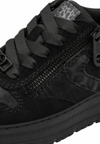 Baskets noires avec lacets épais, fermeture éclair latérale, semelle texturée et un petit accent imprimé léopard sur la languette.
