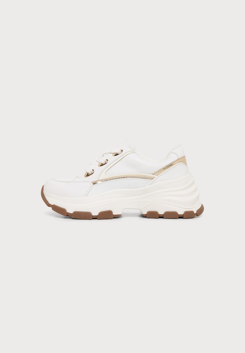 Λευκό chunky sneaker με χοντρή καφέ σόλα με σχέδιο, κορδόνια μπροστά και λεπτές χρυσές λεπτομέρειες στο πλάι και στη φτέρνα.