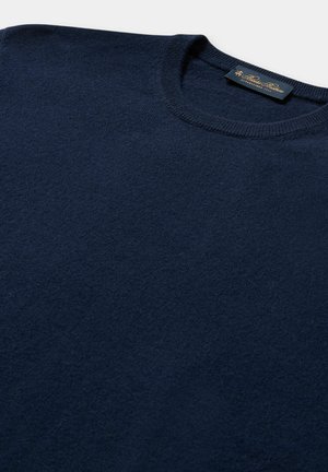 Námořnická modrá svetr s kulatým výstřihem, měkká textura, jednoduchý design, žebrovaný límec; na límci se nachází štítek se zlatým textem.