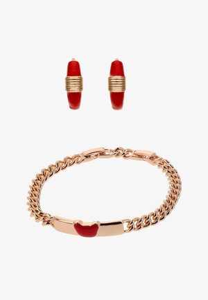 Bracelet chaîne en ton or avec détail cœur en émail rouge, accompagné de boucles d'oreilles créoles assorties en émail rouge et ton or.