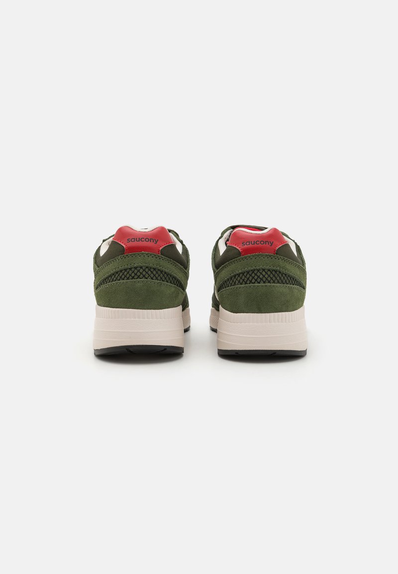 Scarpe da ginnastica in suede verde con un accentuazione rossa sul tallone, dettagli in rete e una suola intermedia bianca imbottita; suola esterna in gomma nera.