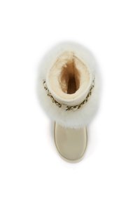 Botte de couleur crème avec col en fausse fourrure, intérieur moelleux et accent en chaîne dorée. Surface lisse avec bout arrondi et semelle plate.