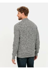 Grauer Strickpullover mit texturiertem Muster, gerippten Bündchen und rundem Halsausschnitt, mit einem diskreten Logo-Patch auf der linken Schulter.