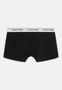 Čierne bavlnené boxerky s bielym elastickým pásom, na ktorom sa opakuje text "Calvin Klein". Hladká textúra, priliehavý strih.