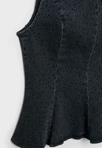 Czarny top bez rękawów z teksturowanej tkaniny, ozdobiony małymi, rozproszonymi błyszczącymi kropkami oraz rozkloszowanym dołem. Gładkie, miękkie wykończenie.