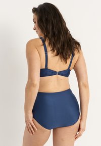 Marineblauwe high-waisted bikini onderkant en bijpassende bralette, gemaakt van een gladde stof met verstelbare banden en sluiting op de rug.