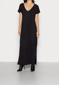 Svart klänning i ankellängd med djup V-ringning, korta ärmar, sidöppningar och lös passform, tillverkad av mjukt och lätt material.