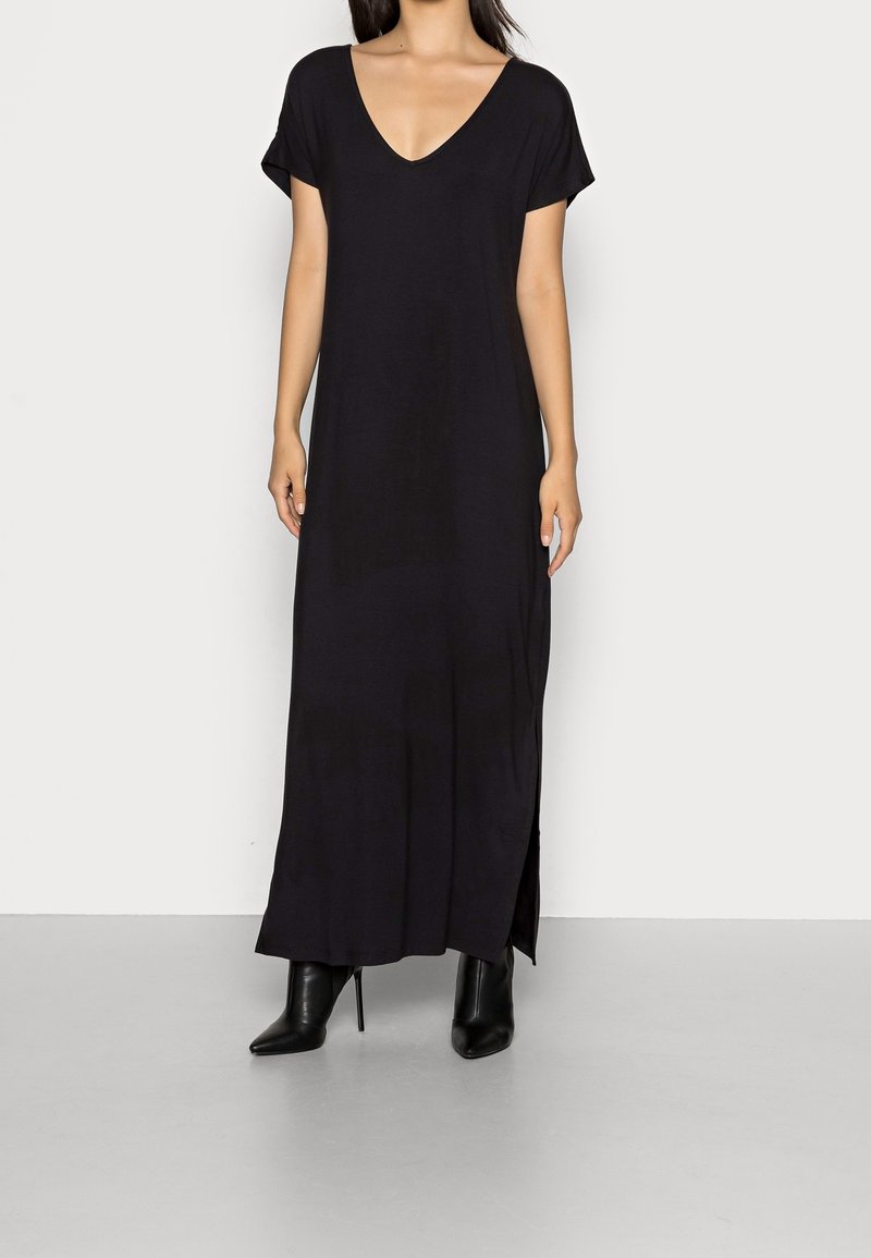 Svart klänning i ankellängd med djup V-ringning, korta ärmar, sidöppningar och lös passform, tillverkad av mjukt och lätt material.
