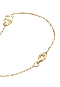 Bracelet doré avec une chaîne délicate et un fermoir en forme de cœur, fermé par un crochet de homard. Texture lisse et raffinée tout au long.