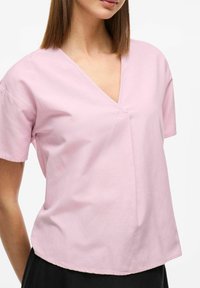 Rosa kortärmad T-shirt med V-ringning i mjuk bomull, med en subtil sömdetalj och en avslappnad passform, med en något längre bakdel.