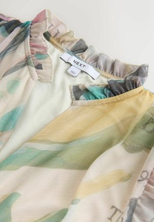 Hiekkainen kukkakuvioinen pusero, jossa on röyhelökaulus; pastelliväreissä pinkki, vihreä ja keltainen; kangas näyttää kevyeltä ja sileältä.