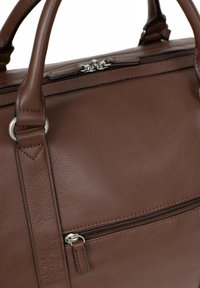Borsa a mano in pelle marrone con superficie testurizzata, dotata di due manici superiori, chiusura con zip e una tasca frontale con zip con dettagli in argento.