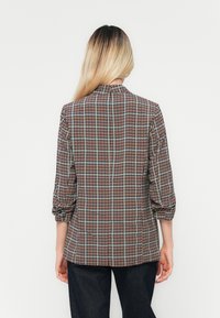 Camicia con colletto in un motivo a quadri multicolore, con maniche a tre quarti, tessuto leggero e vestibilità sartoriale.