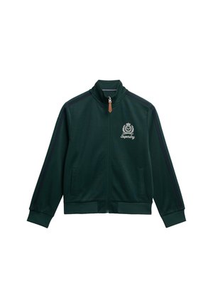 Veste zippée verte en tissu lisse, dotée d'un col montant, de poches latérales, d'accents noirs sur les épaules et d'un logo brodé.