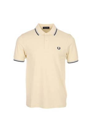 Beiges Poloshirt mit kurzen Ärmeln, dunkelblauem Besatz an Kragen und Ärmeln, zweiknöpfiger Blende und kleinem dunkelblauem Logo auf der Brust.