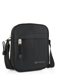 Bolso de hombro de tela negra con forma rectangular, cierre de cremallera, correa ajustable y detalle de logo en relieve en la parte frontal.