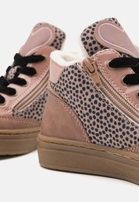 Høye joggesko med rosa lakkoverdel, svarte prikker, semsket skinn-detaljer, myk fôr og glidelås-lukking.
